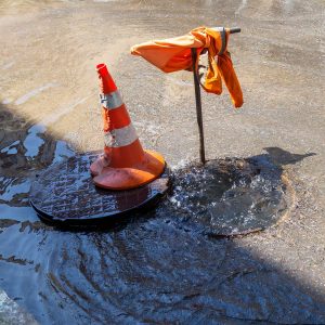 Accident of water supply, sewage. Water fountain pours out from under the road sewer. Breakthrough sewerage system
