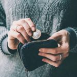 Hands holding british pound coin and small money pouch by 123rf