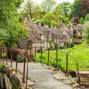 Old footbridge and traditional Cotswold cottages, Bibury, England, UK.