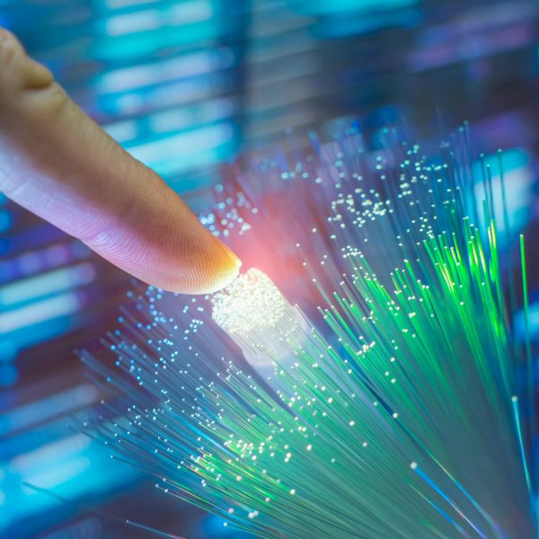 finger touching fiber optic on technology background