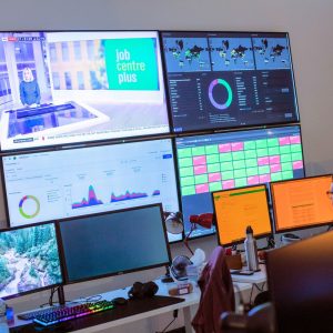 Developer sitting in front of a wall of monitors at Tramshed Tech