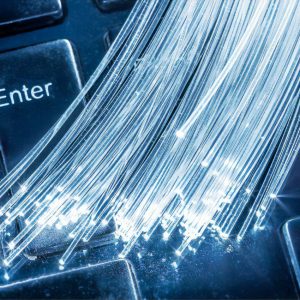 Bundle of optical fibers with lights in the ends lay on keyboard.